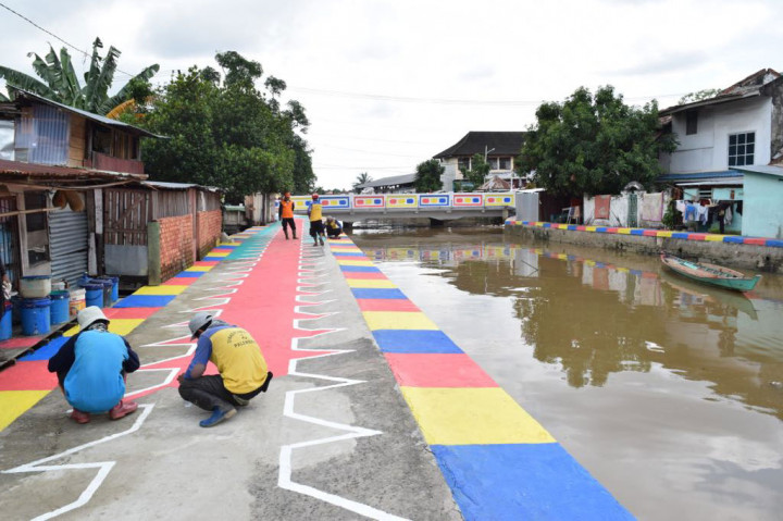 Petugas melakukan pengecatan warna-warni di tepian Sungai Sekanak, Palembang, Sumsel. Kawasan yang dahulu terkenal kumuh tersebut kini tengah bersolek. MI/Dwi Apriani