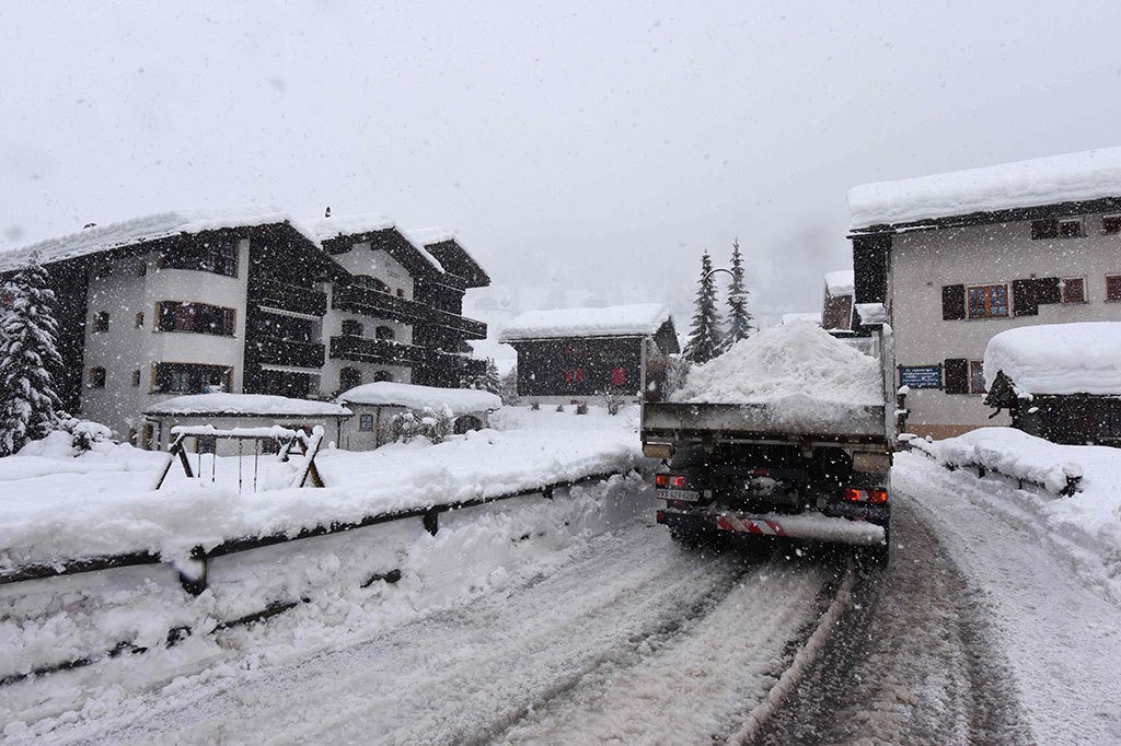Para pekerja berusaha keras membersihkan salju dari jalur kereta api di stasiun kereta Zermatt, setelah hujan salju lebat membuat lebih dari 13.000 wisatawan terjebak. 