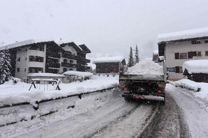 Para pekerja berusaha keras membersihkan salju dari jalur kereta api di stasiun kereta Zermatt, setelah hujan salju lebat membuat lebih dari 13.000 wisatawan terjebak. 