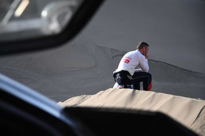 Loeb termangu di dekat mobilnya yang terjebak di lubang pasir. Karena rekannya Elena cedera, Loeb kemudian memutuskan untuk mundur dari reli Dakar.