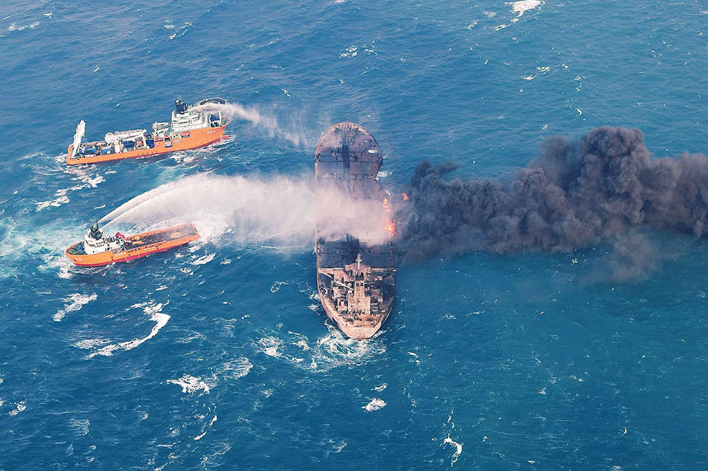 Foto yang diambil pada 10 Januari dan dirilis pada 11 Januari 2018 oleh Kementerian Perhubungan Tiongkok menunjukkan sebuah kapal 'Shen Qian Hao' (kiri atas) menyemprotkan busa ke kapal tanker minyak 'Sanchi' yang terbakar di laut lepas pesisir China timur.