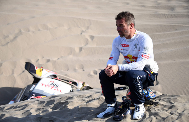 Sebastian Loeb tercenung setelah Peugeot-nya tak mampu lagi berkutik dari jebakan pasir lembut. Pereli unggulan pasangan Daniel Elena ini mundur dari kompetisi.