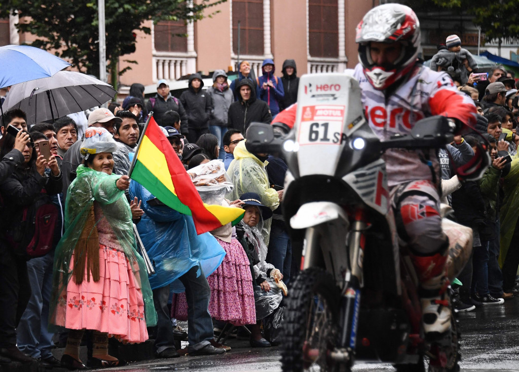 Seorang warga melambaikan bendera Bolivia di garis finish etape enam di La Paz, Bolivia.