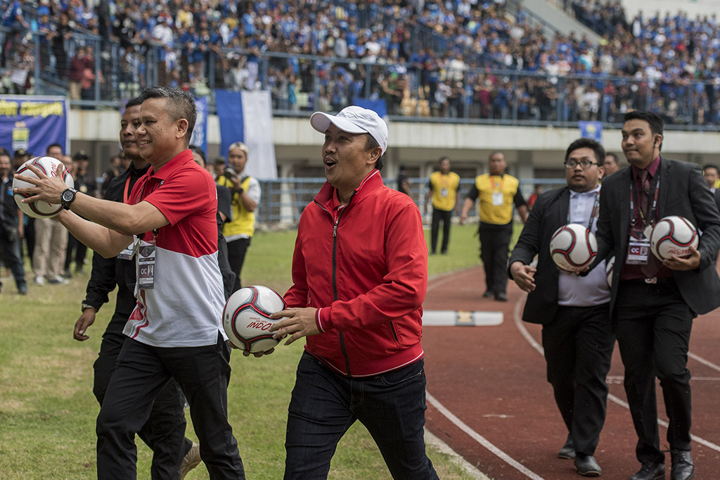 Menteri Pemuda dan Olahraga Imam Nahrowi (tengah) bersama Ketua Pelaksana Piala Presiden Berlinton Siahaan (kiri) membagikan bola bertandatangan Presiden Joko Widodo ke Suporter pada pembukaan Piala Presiden 2018 di Stadion Gelora Bandung Lautan Api, Bandung, Jawa Barat.