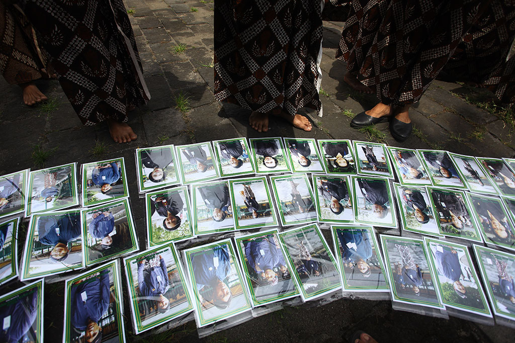 Abdi dalem mengamati foto yang dijajakan seusai diwisuda di Bangsal Ksatriyan, Keraton Yogyakarta.