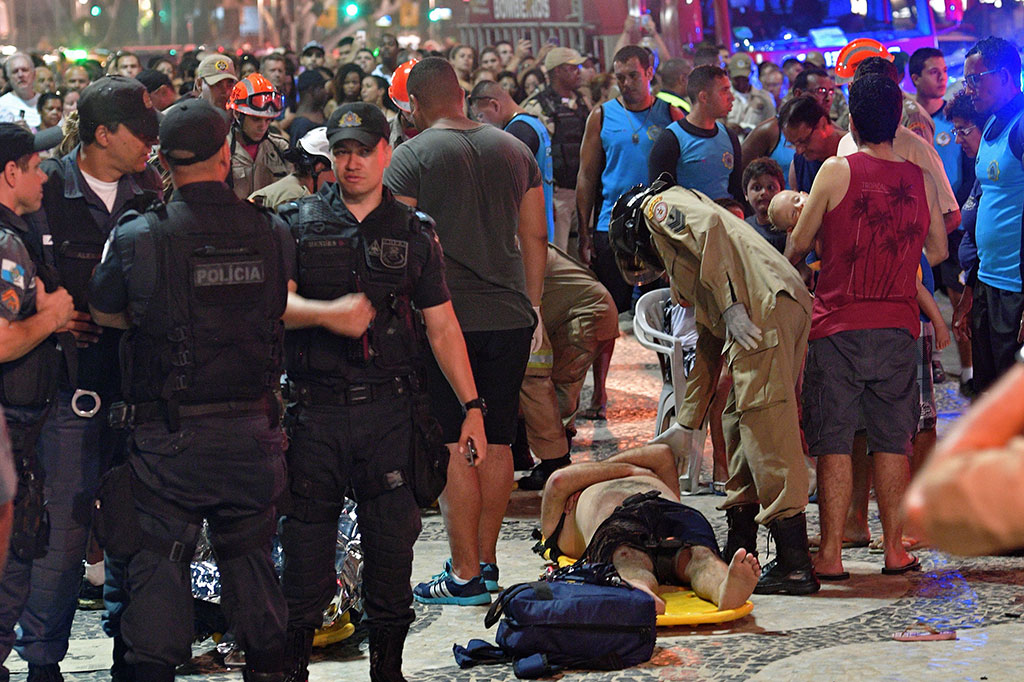 Petugas mengevakuasi korban luka-luka setelah sebuah mobil menabrak kerumunan pejalan kaki di sebuah trotoar di pantai Copacabana, Rio de Janeiro, Brasil, Kamis, 18 Januari 2018 waktu setempat.