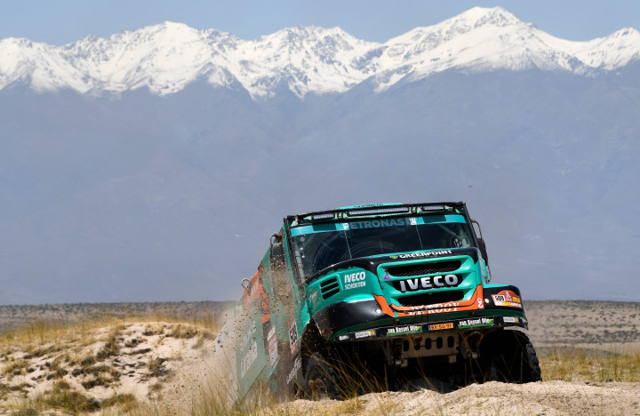 Salju di puncak pegunungan Andes nampak di belakang Iveco pacuan tim Belanda yang menerjang gunung pasir.