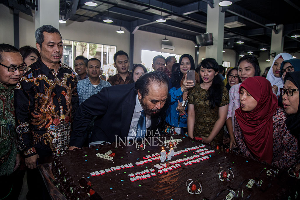 Chairman Media Group Surya Paloh (tengah) didampingi (dari kiri) Direktur Utama Media Indonesia Firdaus Dayat, Direktur Pemberitaan Media Indonesia Usman Kansong dan karyawan Media Indonesia meniup lilin perayaan HUT ke-48 Media Indonesia di kantor Media Group, Kedoya, Jumat (19/1).