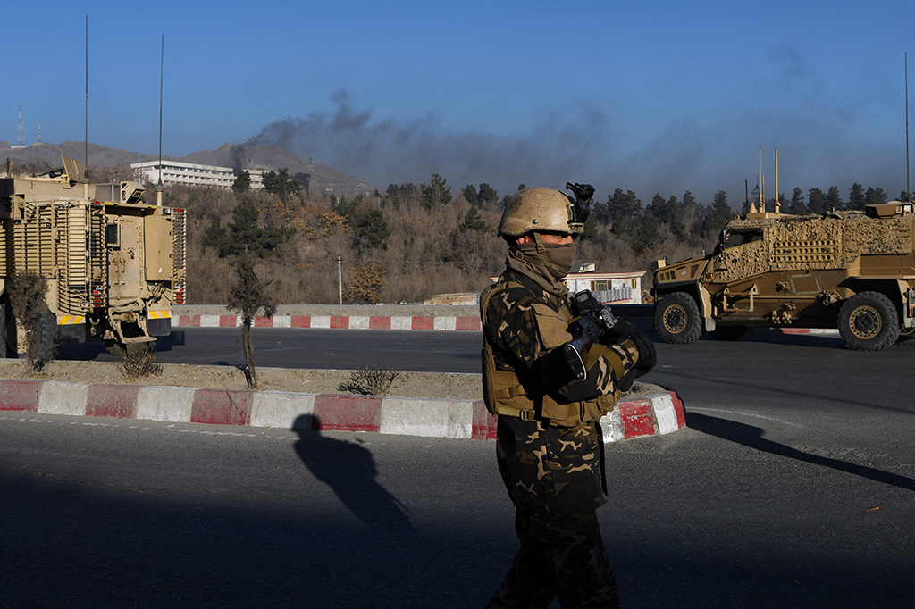 Asap tebal tampak membubung dari hotel tersebut. Kendaraan militer AS berada di dekat hotel bersama dengan polisi dari Afghanistan.