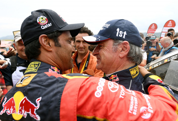 Nasser Al-Attiyah (kiri) memeluk dan mengucapkan selamat kepada Carlos Sainz setibanya mereka di garis finish. Nasser dari Tim Toyota adalah juara umum 2017 dan 2016.