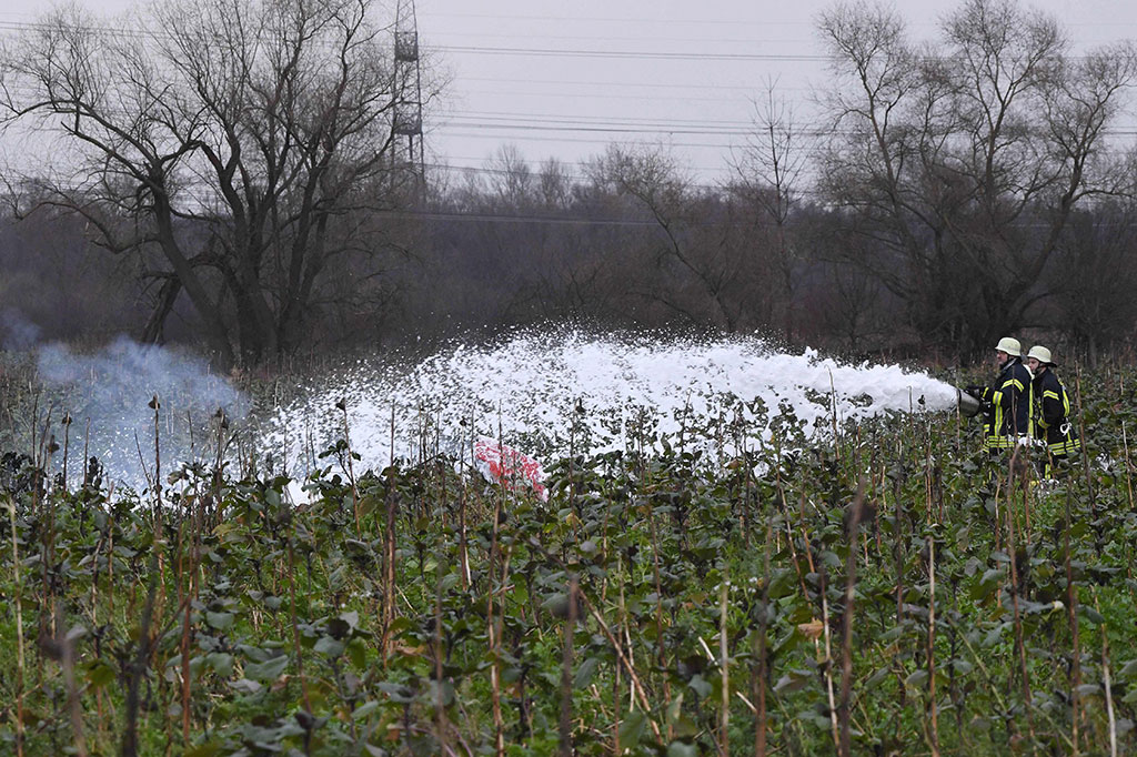 Petugas pemadam kebakaran berusaha memadamkan api yang membakar pesawat setelah sebuah pesawat kecil bertabrakan di udara dengan helikopter di Kota Philippsburg, Jerman,  Selasa, 23 Januari 2018 waktu setempat.