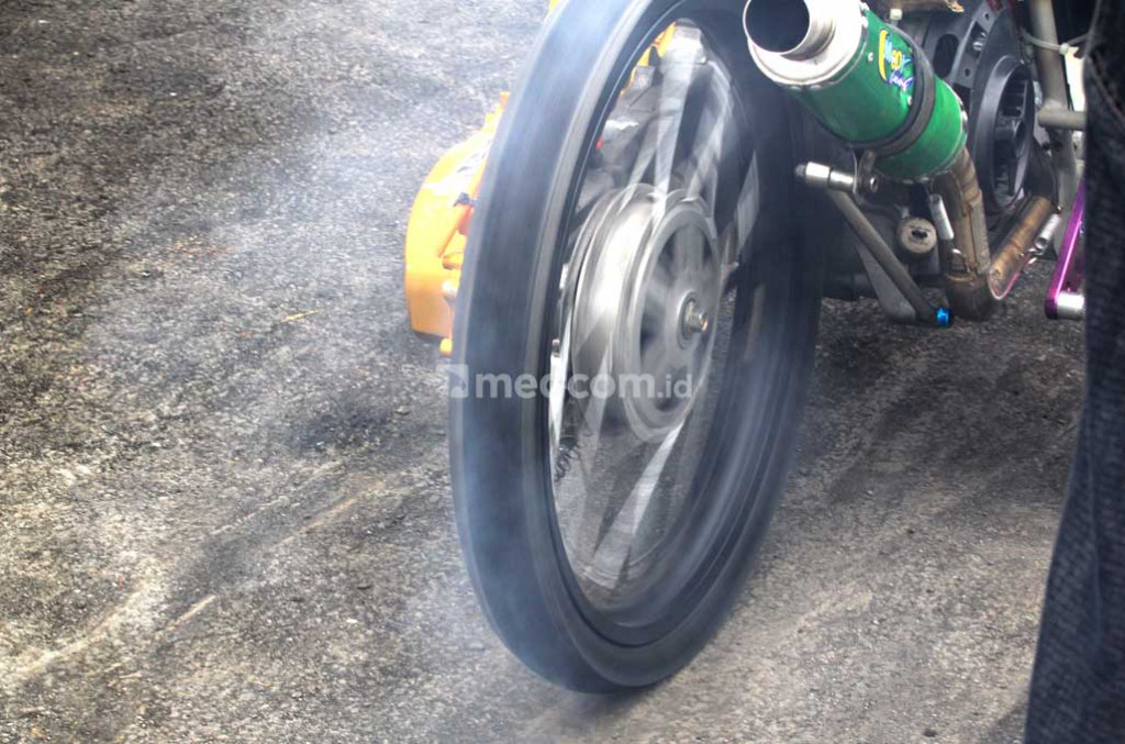 Burn out, sengaja dilakukan para dragster, untuk membuat cengkeraman roda belakang lebih baik saat berakselerasi dan meminimalisir tenaga yang terbuang percuma. medcom.id/Ahmad Garuda
