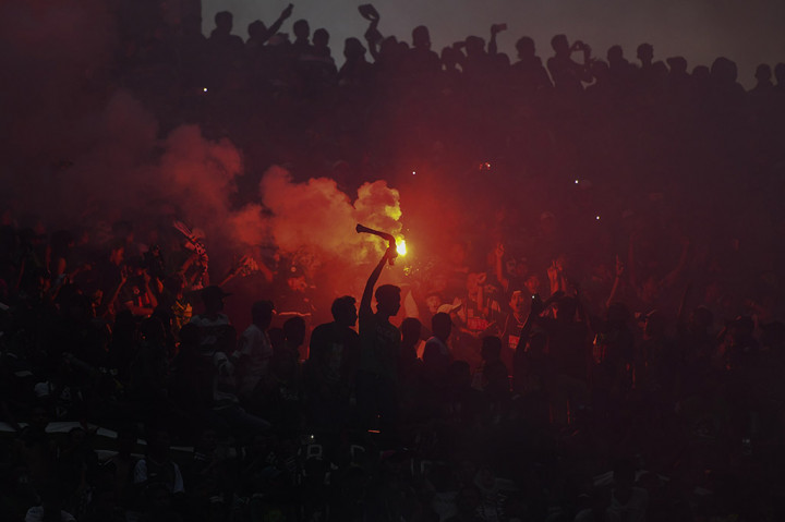 Suporter Persebaya Surabaya menyalakan flare ketika laga Persebaya Surabaya melawan Madura United pada babak penyisihan Grup C Piala Presiden 2018 di Gelora Bung Tomo, Surabaya. 