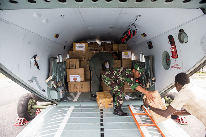 Prajurit TNI bersama warga melakukan bongkar muat bantuan makanan dan obat-obatan di Ewer, Kabupaten Asmat, Papua.