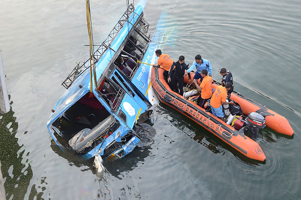 Polisi mencari korban yang diduga masih terjebak di dalam bus yang terjun ke Sungai Bhairav, negara bagian Bengal Barat, India, Senin, 29 Januari 2018. 