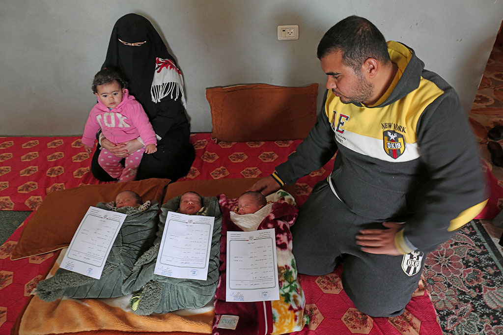 Pasangan Nidal al-Saiqli (kanan) dan Islam (kiri) berpose bersama putri mereka Dalal dan anak kembar tiga mereka yang baru lahir, di rumah mereka di kota selatan Gaza, Khan Yunis, Jumat, 2 Februari 2018.