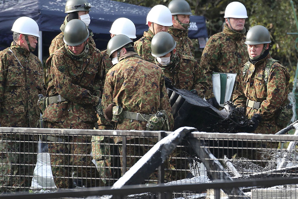 Petugas mengevakuasi puing-puing helikopter Apache yang jatuh di perumahan di Kota Kanzaki, Prefektur Saga.