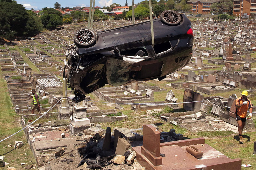 Mobil kemudian menabrak pohon dan dinding permakaman, sebelum terbang beberapa meter di udara.