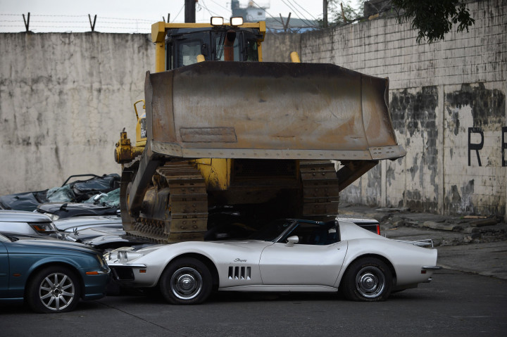 Alat berat ekskavator melindas deretan sportcar mewah yang merupakan barang selundupan. 