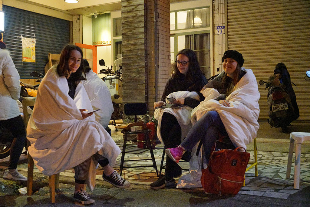 Sementara tiga wisatawan asal Inggris menghangatkan badan mereka dengan selimut.