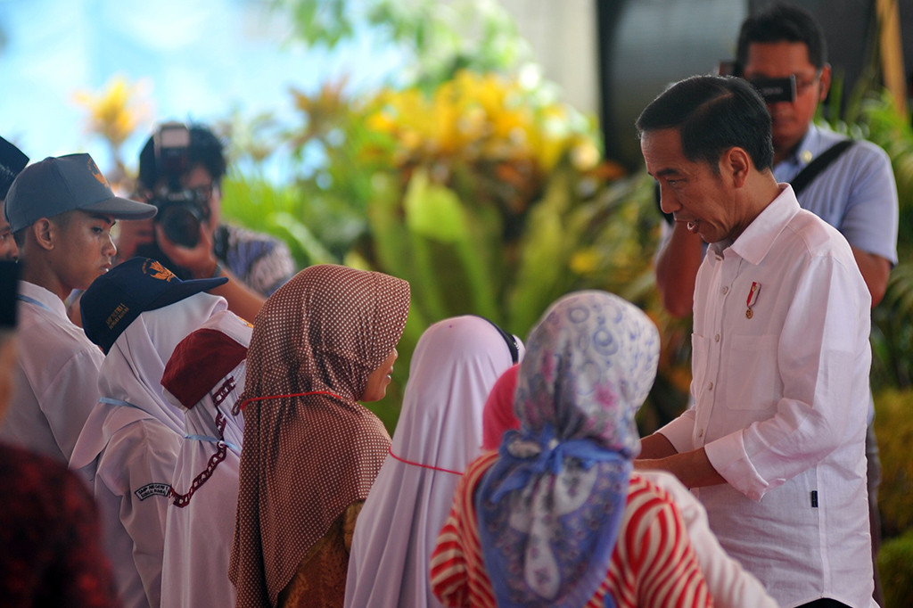 Presiden Joko Widodo menyerahkan kartu Indonesia pintar (KIP) kepada pelajar di Sitiung, Kab.Dharmasraya, Sumatera Barat.