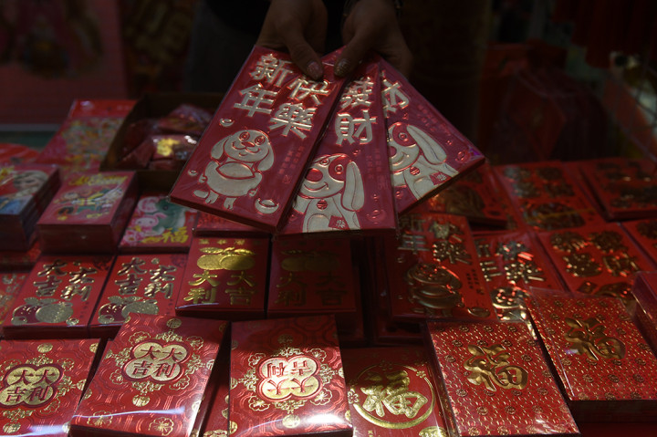 Pedagang menunjukan amplop angpao bermotif anjing yang dijual di toko pernak-pernik Imlek di Surabaya, Jawa Timur. ANTARA/Zabur Karuru