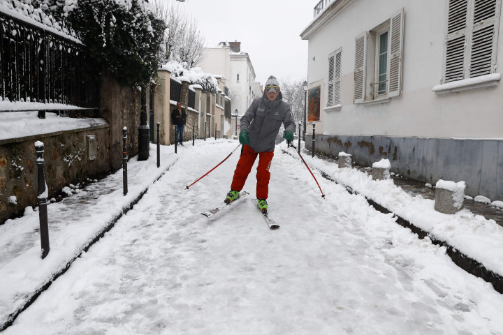 Pemain ski asyik susuri jalanan di Paris yang tertutup salju.