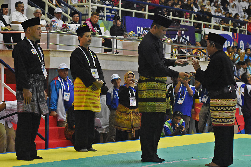 Pesilat Senior Tri Sipit S. menyerahkan senjata golok kepada Wakil Ketua PB IPSI Edhy Prabowo saat seremoni 