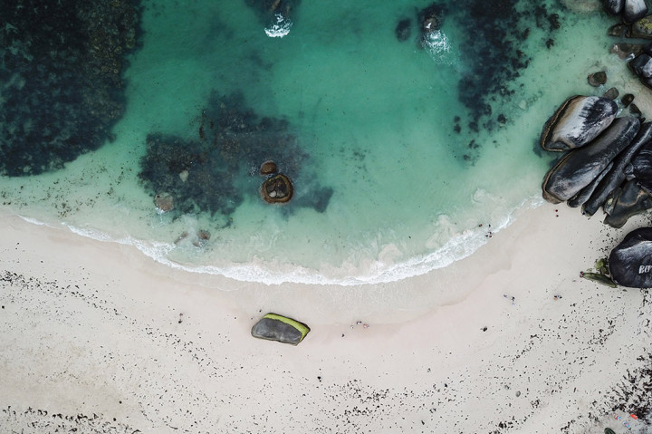 Keindahannya terletak dari hamparan pasir putih dan air laut yang berwarna hijau toska kebiruan. Ditambah lagi bebatuan tinggi menjulang yang membuat pantai ini terlihat eksotis. ANTARA/Rivan Awal Lingga