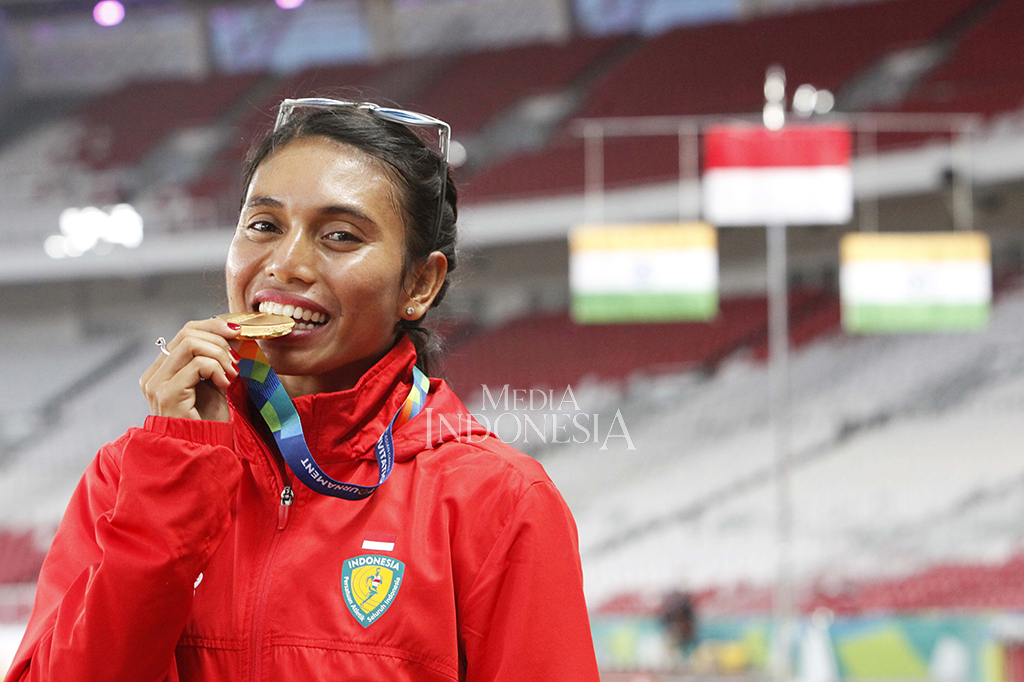 Peloncat jauh Indonesia Maria Natalia Londa menunjukkan medali emas yang diraihnya pada test event Asian Games 2018 di Stadion Utama Gelora Bung Karno, Senayan, Jakarta. 
