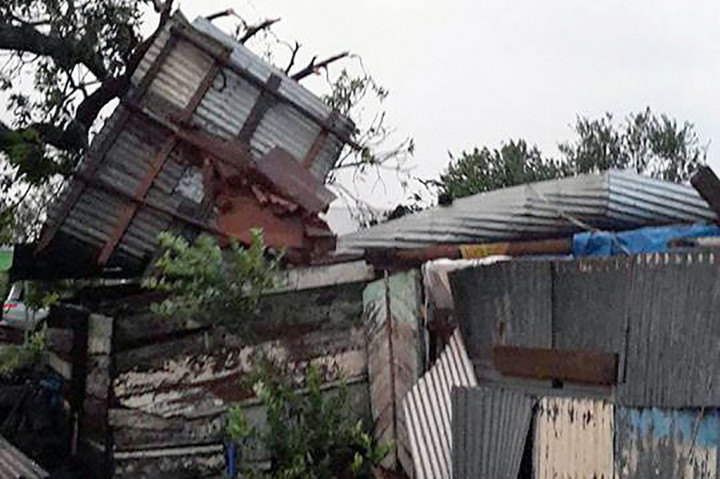 Atap rumah penduduk beterbangan, pohon dan tiang listrik tumbang setelah disapu badai Gita yang berkekuatan 230 kmh (142 mph).