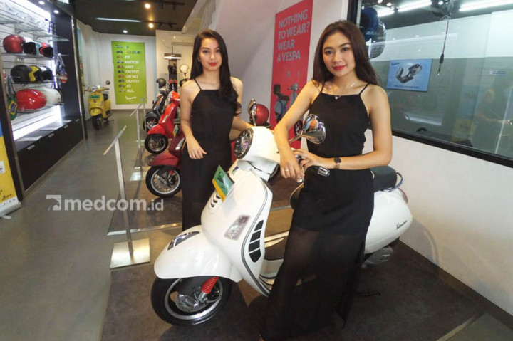 Model berpose bersama produk Piaggio dan Vespa.