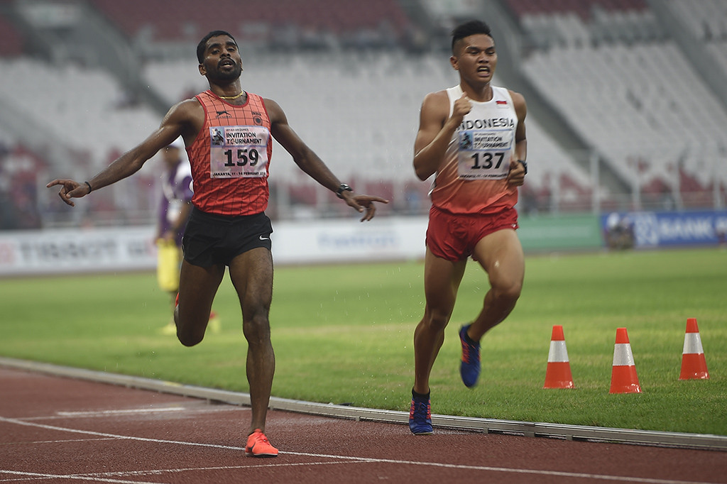 Pelari India Lakshmanan Govindan (kiri) memasuki garis finis disamping pelari Indonesia Wahyudi Putra (kanan) yang tertinggal satu lap pada final Lari 5000 Meter Putra 18th Asian Games Invitation Tournament di Stadion Utama Gelora Bung Karno, Jakarta. ANTARA/Sigid Kurniawan
