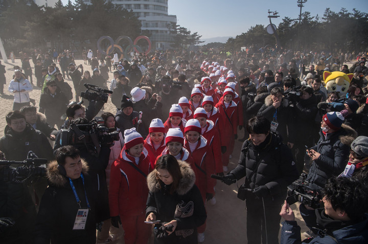 Cheerleader yang mengenakan seragam merah dan topi merah-putih itu berkunjung ke Pantai Gyeongpo, Gangneung, Korsel. Begitu tiba, sudah banyak wartawan yang menunggu untuk meliput mereka.