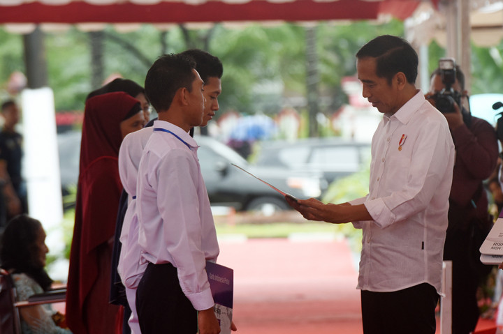 Presiden Joko Widodo menyerahkan secara simbolik Kartu Program Keluarga Harapan (PKH) dan Kartu Indonesia Pintar (KIP) di Lapangan Syech Yusuf, Kabupaten Gowa, Sulsel.