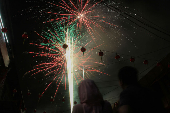Pengunjung melihat kembang api di malam pergantian Tahun Baru Imlek 2569/2018 yang dipusatkan di Kampung Tionghoa Melayu Pekanbaru, Riau, Jumat, 16 Februari 2018 dini hari.