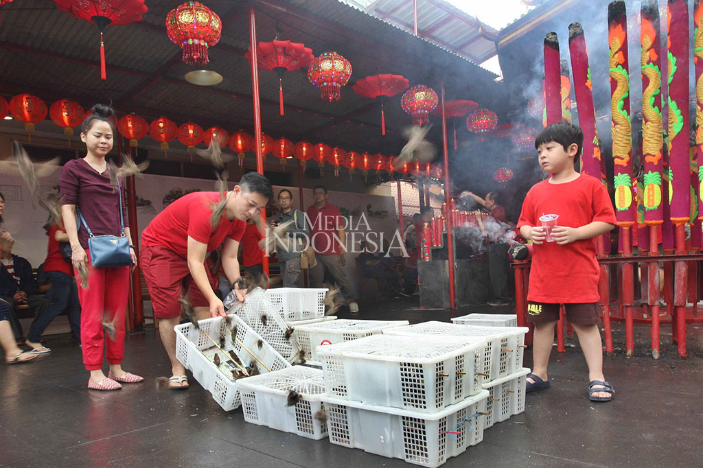 Warga melepas burung seusai berdoa di Wihara Dharma Bhakti di Petak Sembilan, Glodok, Jakarta Barat. Ritual tersebut dipercaya bisa memperpanjang umur dan dapat mengasihi makhluk hidup yang ada di bumi.