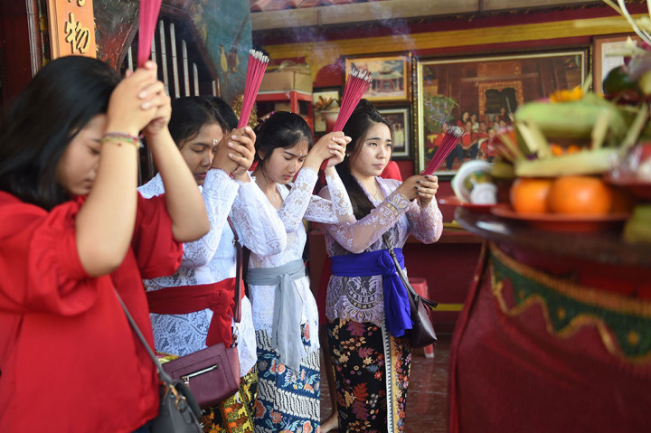 Umat Buddha di Bali bersembahyang di sebuah wihara di Kuta, Denpasar, Jumat. AFP/Sonny Tumbelaka