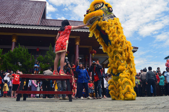 Seorang anak memberikan angpao kepada barongsai di Wihara Karuna Dipa Palu, Sulawesi Tengah. Atraksi barongsai itu digelar untuk merayakan Tahun Baru Imlek 2569. ANTARA/Mohamad Hamzah