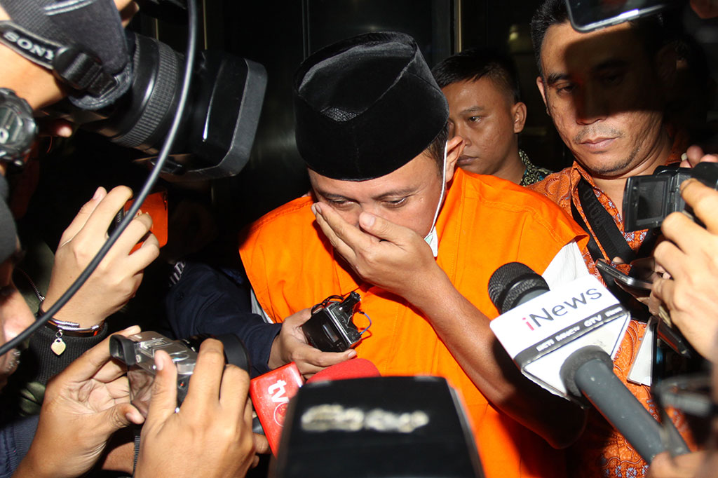 Anggota DPRD Lampung Tengah Rusliyanto menutupi wajahnya usai menjalani pemeriksaan di gedung KPK, Jakarta.