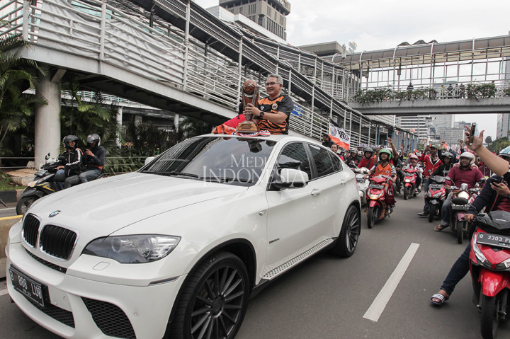 Tauhid Indrasjarief ketua umum Jakmania memegang Piala Presiden saat pawai bersama Jakmania di sepanjang Jalan MH. Thamrin, Jakarta.