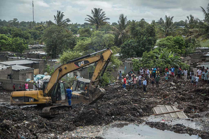 Petugas dibantu alat berat berusaha mencari korban di antara reruntuhan gunungan sampah di distrik miskin di Maputo, Senin, 19 Februari 2018 waktu setempat.