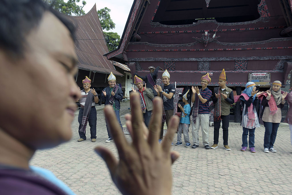 Sejumlah wisatawan menari membentuk lingkaran. Diiringi musik Sordan dan Gondang Sabangunan, mereka menari Tortor di depan sebuah boneka kayu menyerupai bentuk manusia yang disebut Sigale Gale.