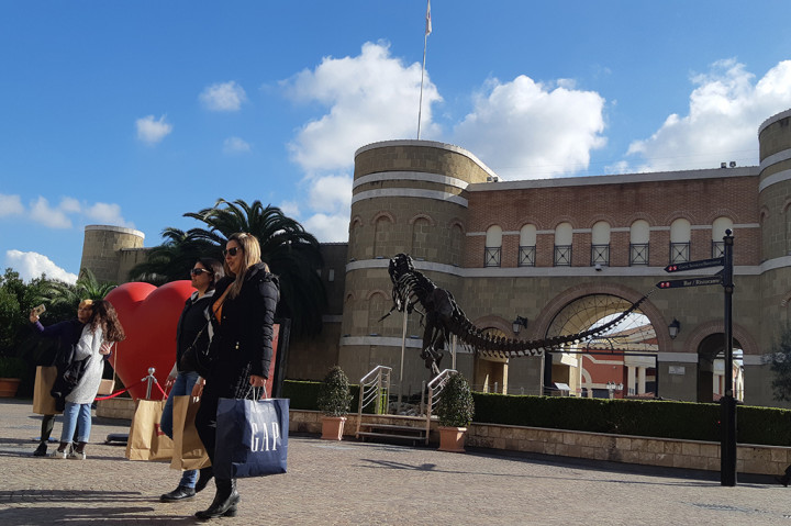 Sejumlah turis berswafoto di kawasan McArthur Glen Castle Romano Designer Outlets, Roma, Italia.