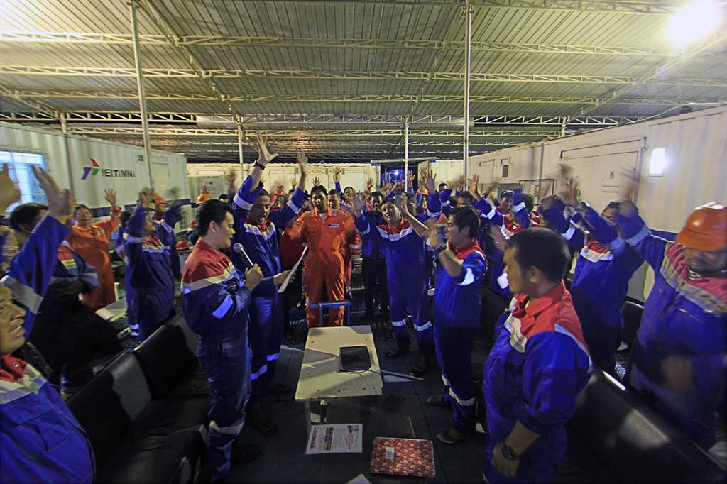 Bergegas para pekerja PT Pertamina Drilling Services Indonesia (PDSI) yang merupakan anak perusahaan dari PT Pertamina (Persero) berkumpul di ruang rapat di antara deretan kontainer tempat tinggal sementara saat masa pengeboran. Pertemuan selain pergantian sif juga mengulas permasalahan yang dihadapi dalam proses pengeboran. Dengan yel-yel penuh semangat mereka awali pengeboran yang akan dilanjutkan malam itu.