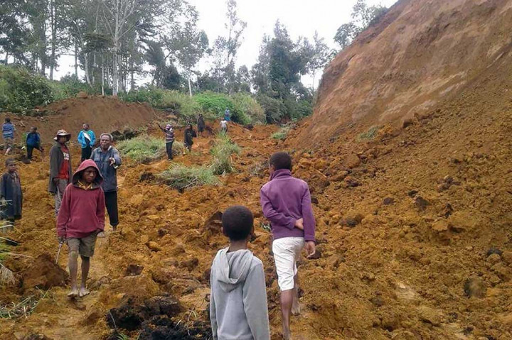 Warga berjalan di lokasi longsor di dekat Desa Ekari di wilayah dataran tinggi Papua Nugini setelah gempa berkekuatan 7.5 SR.