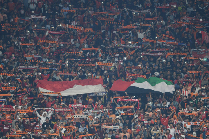 Suporter membentangkan bendera dan syal dalam laga kedua Grup H Piala AFC antara Persija Jakarta melawan Tampines Rovers di Stadion Utama Gelora Bung Karno, Jakarta.
