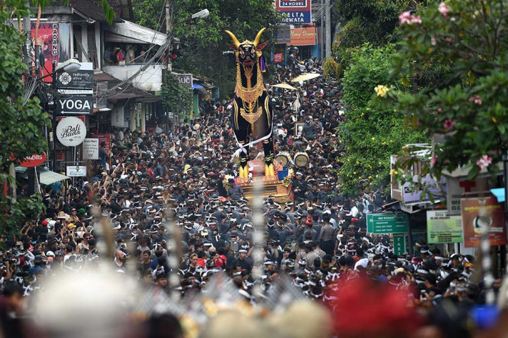 Ribuan warga, wisatawan domestik dan mancanegara memadati Jalan Raya Ubud menyaksikan iring-iringan peti berbentuk sapi yang berisi jenazah keluarga Puri (Kerajaan) Ubud, Anak Agung Niang Agung dalam upacara Ngaben akbar di Desa Peliatan, Ubud, Jumat, 2 Maret 2018.