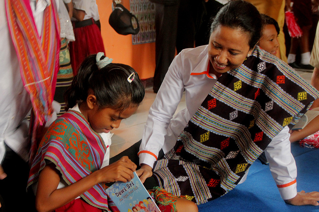 Menteri BUMN Rini Soemarno bercengkrama dengan seorang pelajar SD di Taman Baca Masyrakat usai menyaksikan penyerahan bantuan CSR di Desa Bipolo, Kabupaten Kupang.