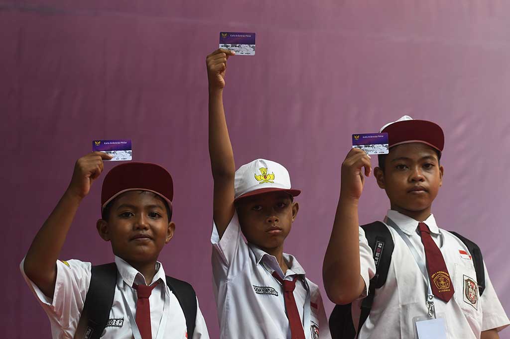 Siswa SD menunjukkan KIP yang mereka terima. 